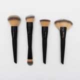 Four makeup brushes with black handles and brown bristles on a light gray background