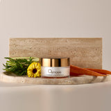 Osmosis Carrot Calendula Mask on a marble platform with carrots and calendula flower 