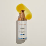 Osmosis Clarify serum bottle with a yellow applicator on a beige background