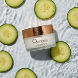 Osmosis Hydraluxe jar surrounded by sliced cucumbers on a water surface
