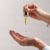 Osmosis Nourish Avocado Facial Oil dropper dripped onto hand